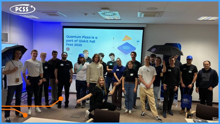 Na zdjęciu widnieje grupa młodych osób stojących na tle obrazu wyświetlanego z rzutnika. Spotkanie dotyczy Quantum Pizza w PCSS.