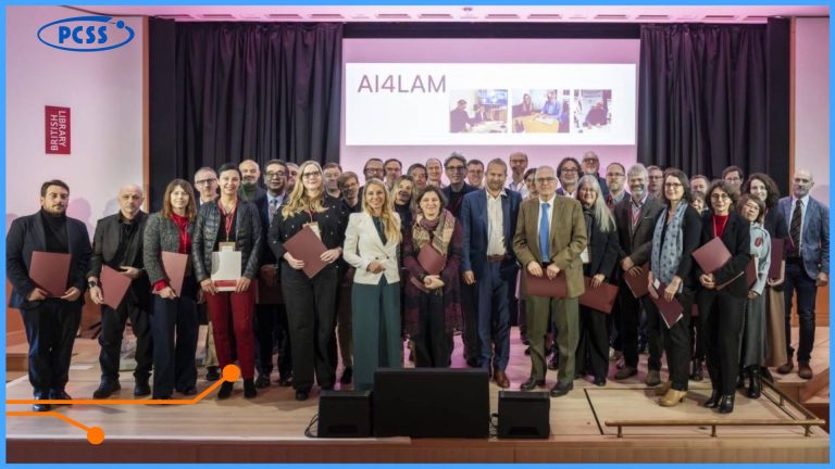 Zdjęcie przedstawia dużą grupę około 40-50 dorosłych osób – przedstawicieli instytucji – stojących razem na scenie podczas konferencji. Tło stanowi ekran z napisem AI4LAM oraz logo British Library (gdzie odbyło się spotkanie) i PCSS (w górnym lewym rogu). Większość uczestników trzyma w dłoniach dokumenty lub teczki (prawdopodobnie Memorandum of Understanding), a cała scena sugeruje moment po formalnym podpisaniu ważnego międzynarodowego porozumienia.