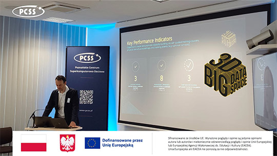 Zdjęcie przedstawia prelegenta stojącego przy mównicy z laptopami w sali konferencyjnej. Obok niego znajduje się baner Poznańskiego Centrum Superkomputerowo-Sieciowego (PCSS) oraz duży ekran projekcyjny wyświetlający prezentację z napisem „Key Performance Indicators” i logo projektu „BIG 3D DATA SPACE”. Na dole grafiki umieszczono pasek informacyjny z godłem Polski, flagą Unii Europejskiej oraz informacją o dofinansowaniu.