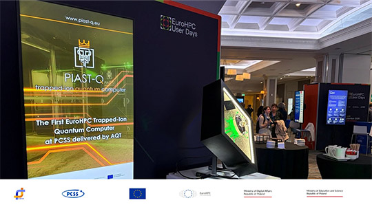 Stoisko PCSS na EuroHPC User Days z bannerem o komputerze PIAST-Q i makietą procesora. W tle widać publiczność konferencji w Dublinie.
