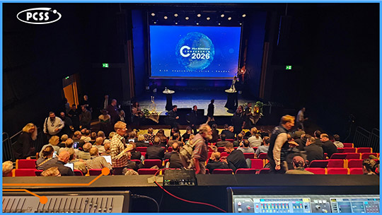 Sala konferencyjna ze stanowiska realizatora. Widok na publiczność w fotelach i scenę z wielkim ekranem z napisem NORDUnet 2026.